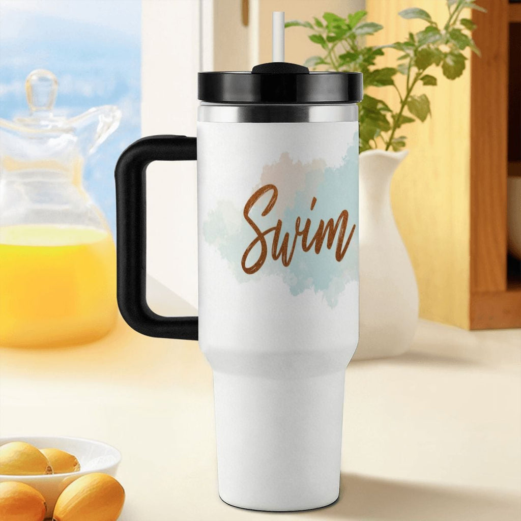 White travel mug with 'Swim Mom' text on a blurred background of a kitchen.