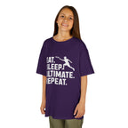 Child wearing a purple t-shirt with 'Eat. Sleep. Ultimate. Repeat.' text and graphic on a white background