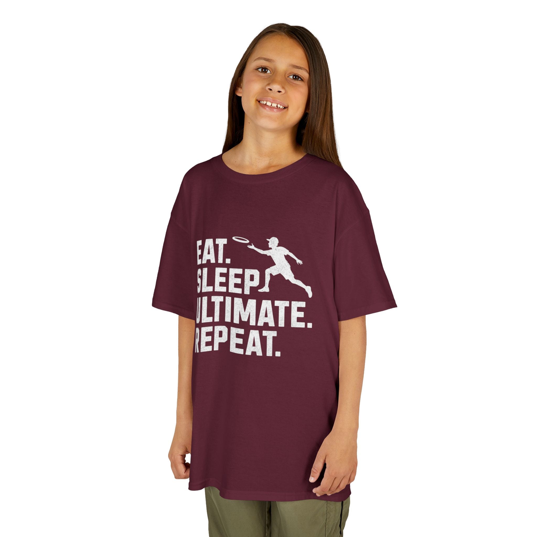 Child wearing a maroon t-shirt with 'Eat. Sleep. Ultimate. Repeat.' text and graphic on a white background