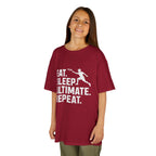 Child wearing a red t-shirt with 'Eat. Sleep. Ultimate. Repeat.' text and graphic on a white background