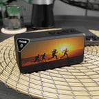 Black Bluetooth speaker with sunset design on a woven mat
