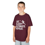 Child wearing a maroon t-shirt with 'Eat. Sleep. Ultimate. Repeat.' text and graphic on a white background