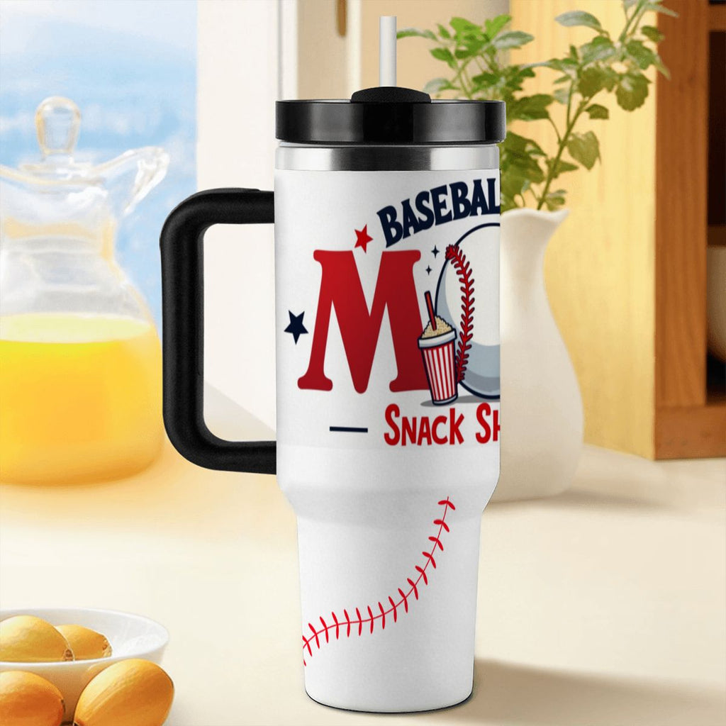 White tumbler with black handle and 'BASEBALL MOM: Snack Shack MVP' design on a blurred background