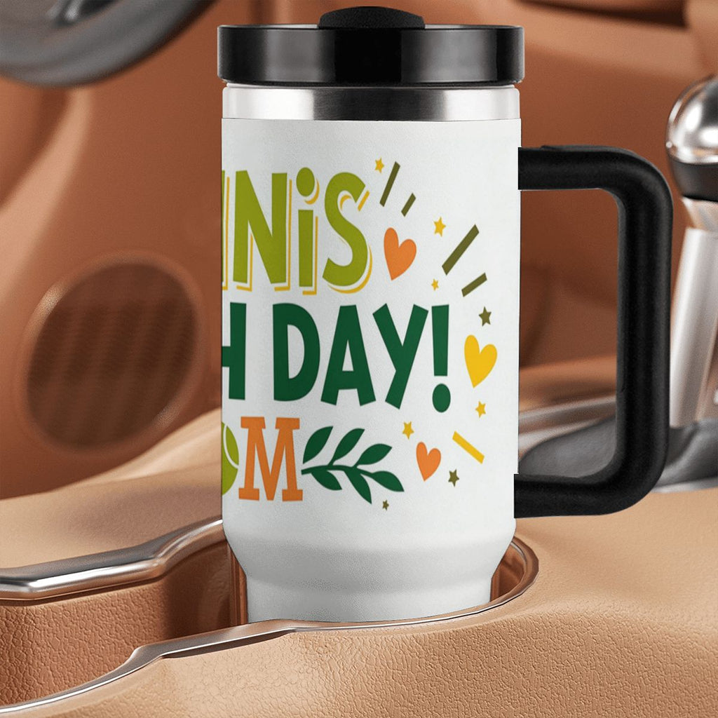 Travel mug with colorful "Tennis Match Day Mom" text and design on a brown leather surface