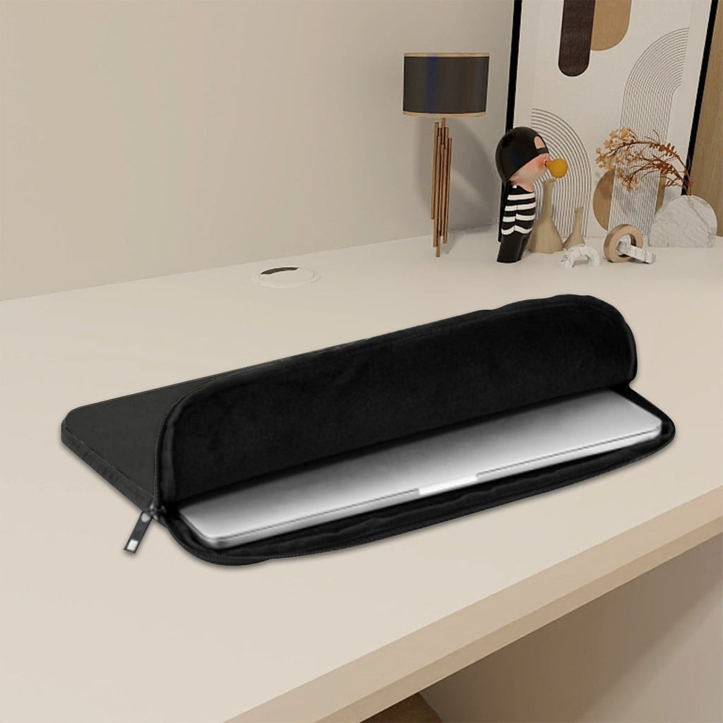 Black laptop sleeve on a desk with decorative items in the background