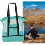 Teal tote bag with black handles and trim, shown outdoors by a mountain lake.