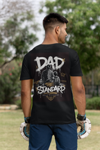 Man wearing a black t-shirt with 'DAD OF THE STANDARD' basketball themed design outdoors.