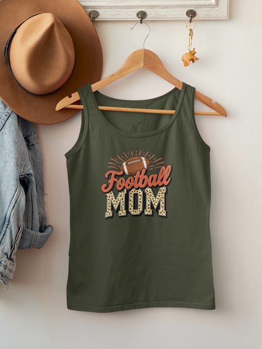 Green tank top with 'Football Mom' text on a wooden hanger against a white wall.