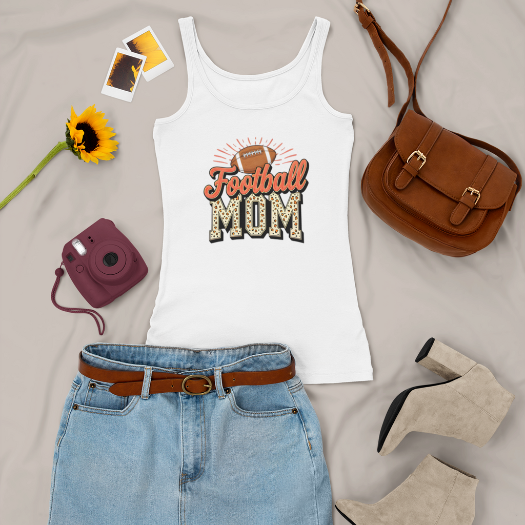 White tank top with 'Football Mom' design, denim skirt, brown purse, sunflower, and camera on a light gray background