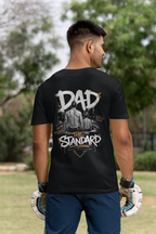 Man wearing a black t-shirt with 'DAD THE STANDARD' male swimmer design outdoors.