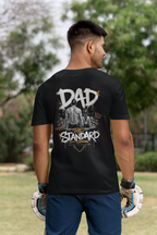Man wearing a black t-shirt with 'DAD THE STANDARD' female swimming design outdoors
