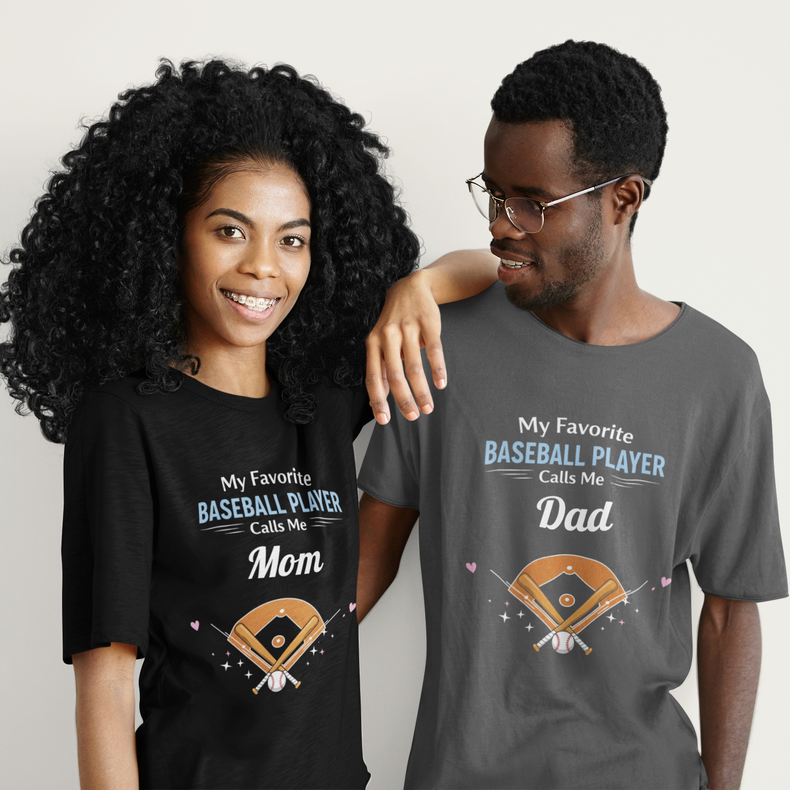 Two people wearing t-shirts with baseball-themed text and graphics.