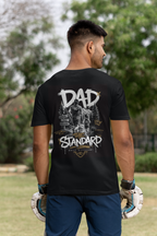 Man wearing a black t-shirt with 'DAD THE STANDARD' cross country girl themed design outdoors.